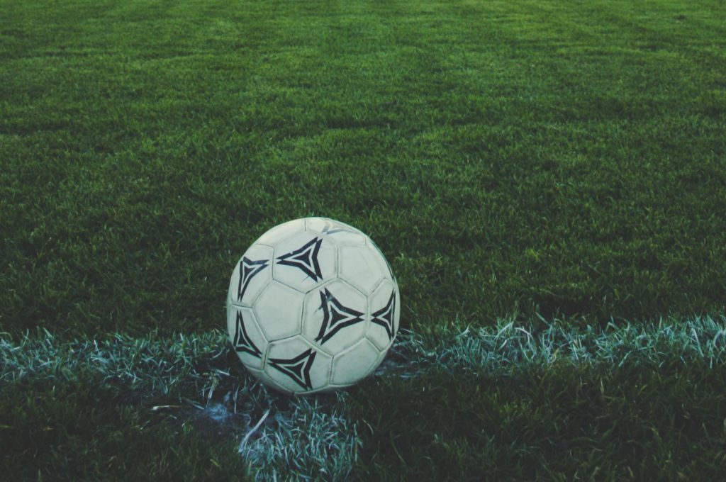 Photo of football on grass pitch