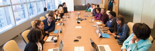 People sitting in a meeting room in an office with laptops